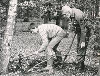 850836 Afbeelding van twee broeders franciscanen die bezig zijn met opruimwerkzaamheden op het landgoed bij ...